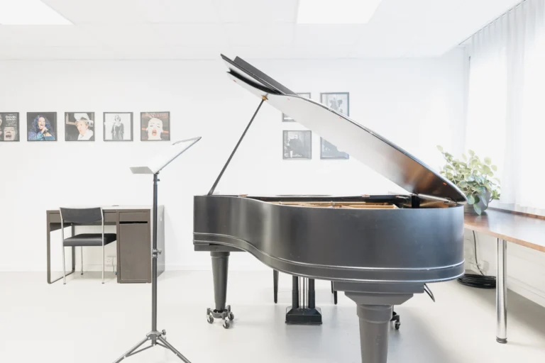 Aufgeklappter Flügel, Notenständer und Tisch in einem grossen Raum.