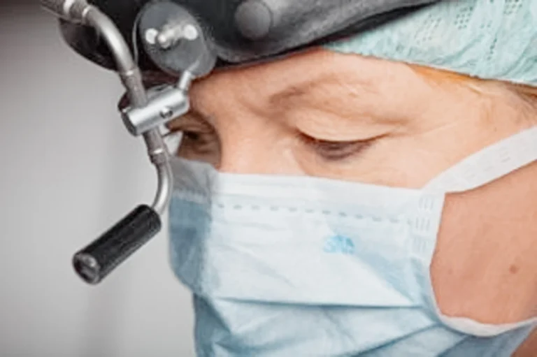 Ärztin mit Maske, Haube und medizinischem Gerät